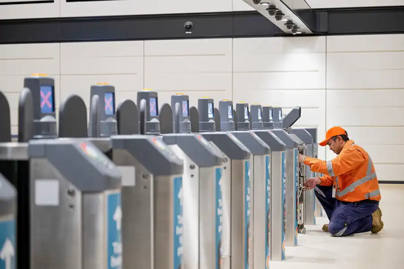 a field technician fixing an out of service fare gate